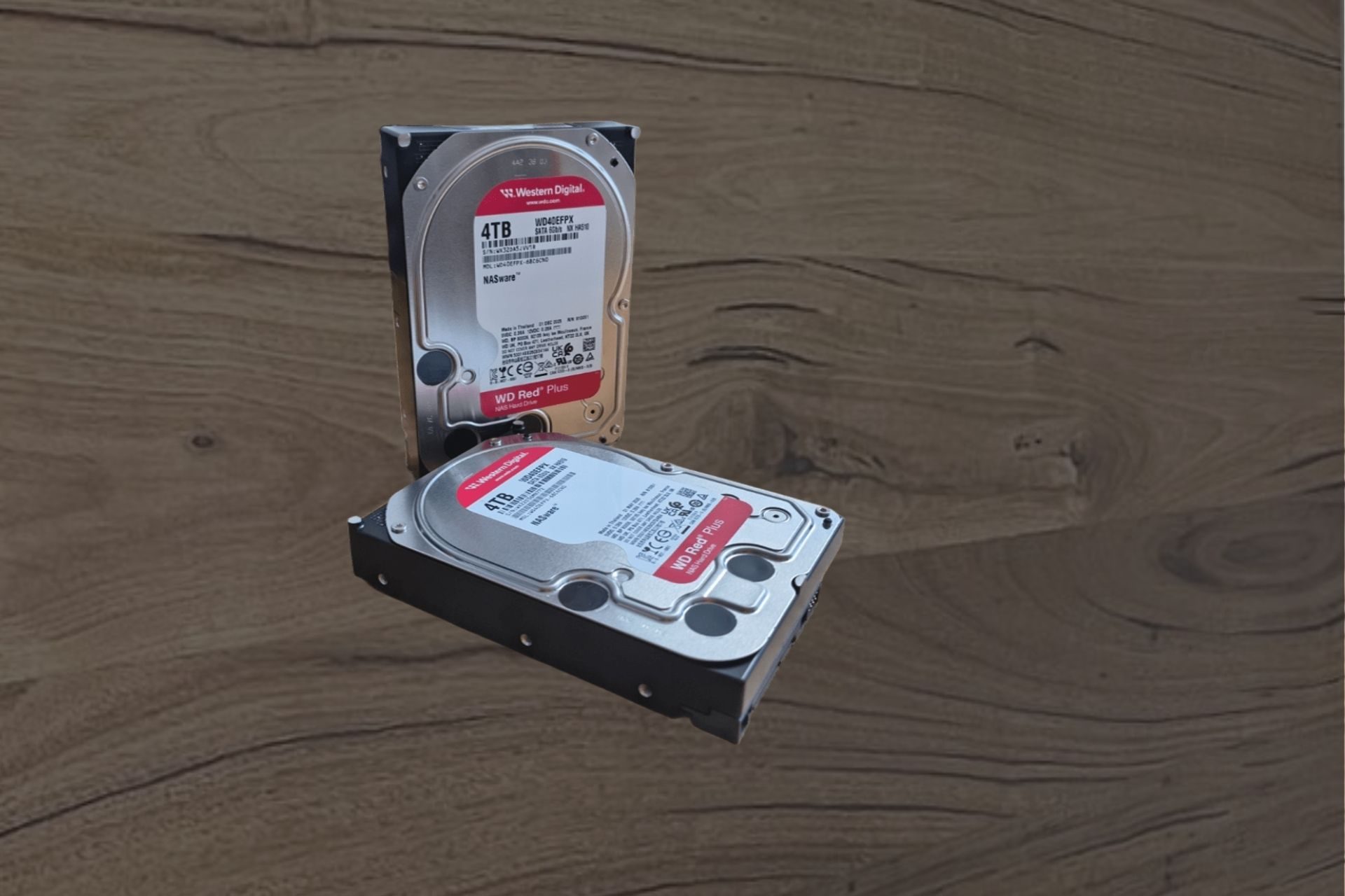 Two 4TB Western Digital WD Red Plus NAS hard drives on a workbench at the Kiwi Data Recovery lab in Auckland, the type of drive recovered from failed NAS and desktop systems